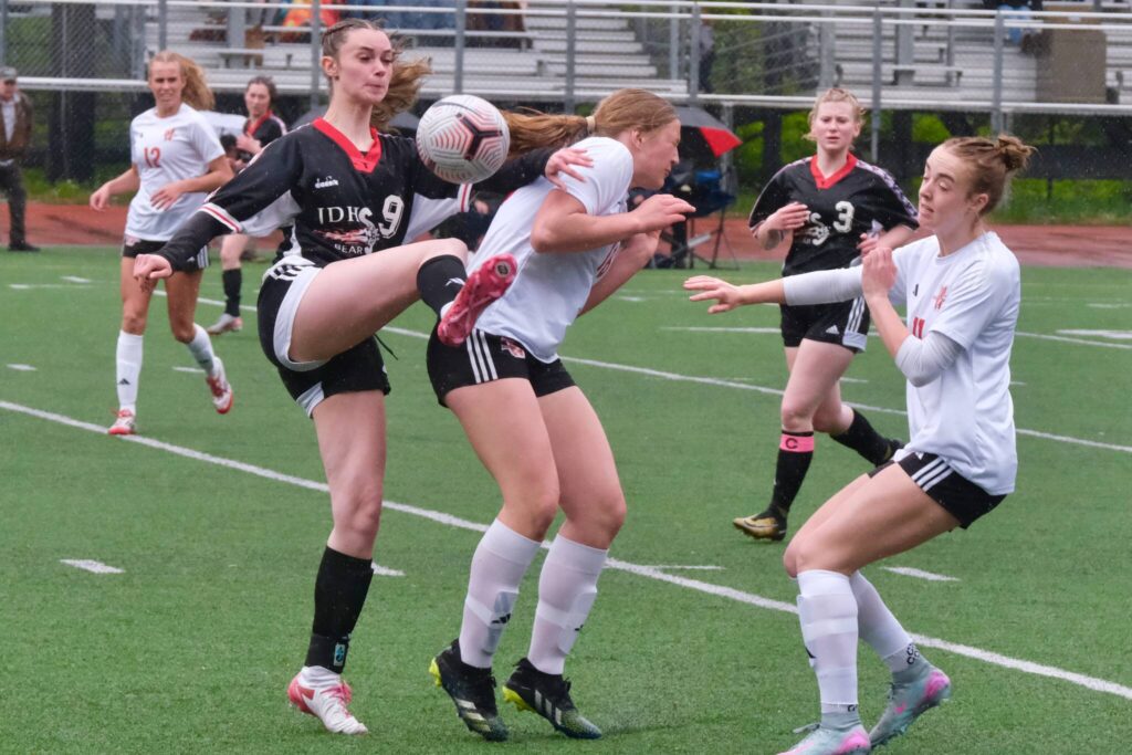 Juneau-Douglas High School: Yadaa.at Kalé senior Ella Orsborn (9) wins a ball against Wasilla as senior teammate Adelyn Buss (3) moves in during the Crimson Bears senior appreciation game Saturday at Adair-Kennedy Memorial Park. (Klas Stolpe / Juneau Empire)