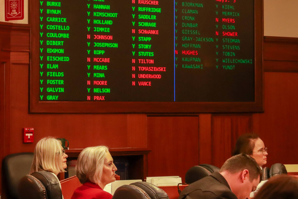 Rep. Andi Story (D-Juneau), Rep. Rebecca Himschoot (I-Sitka), and Rep. Sarah Vance (R-Homer) watch the vote tally during a veto override joint session on an education bill Tuesday, May 20, 2025. (Jasz Garrett / Juneau Empire)