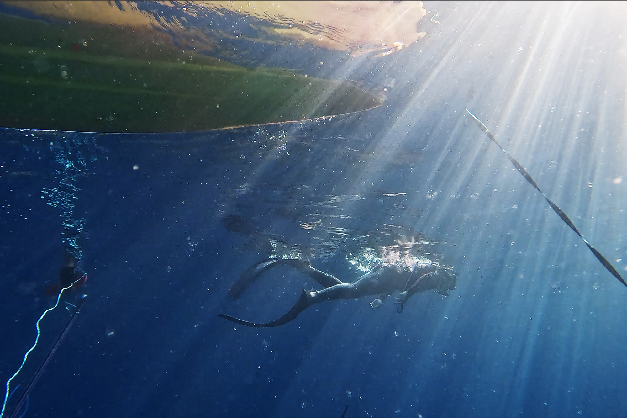 A diver keeps an eye on their teammate during the Kealakekua Bay Non-Native I‘a (fish) Removal Event Sunday, May 18, 2025, in Captain Cook. One diver stayed on the surface to keep an eye on their teammate while the other dove to spearfish. (Kevin Fujii/Civil Beat/2025)