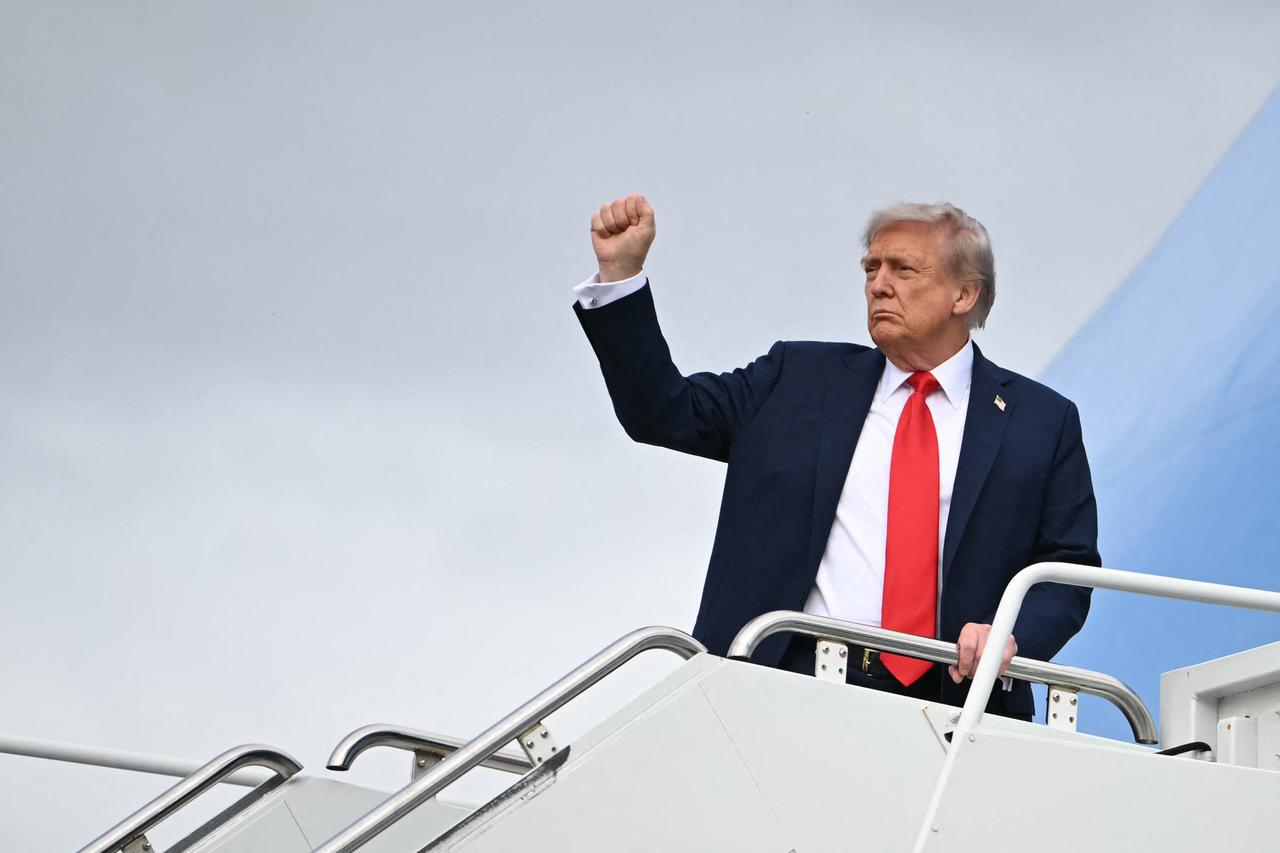 U.S. President Donald Trump raises a fist as he boards Air Force One, in Anchorage, Alaska, U.S., Aug. 15, 2025. (AFP Photo)