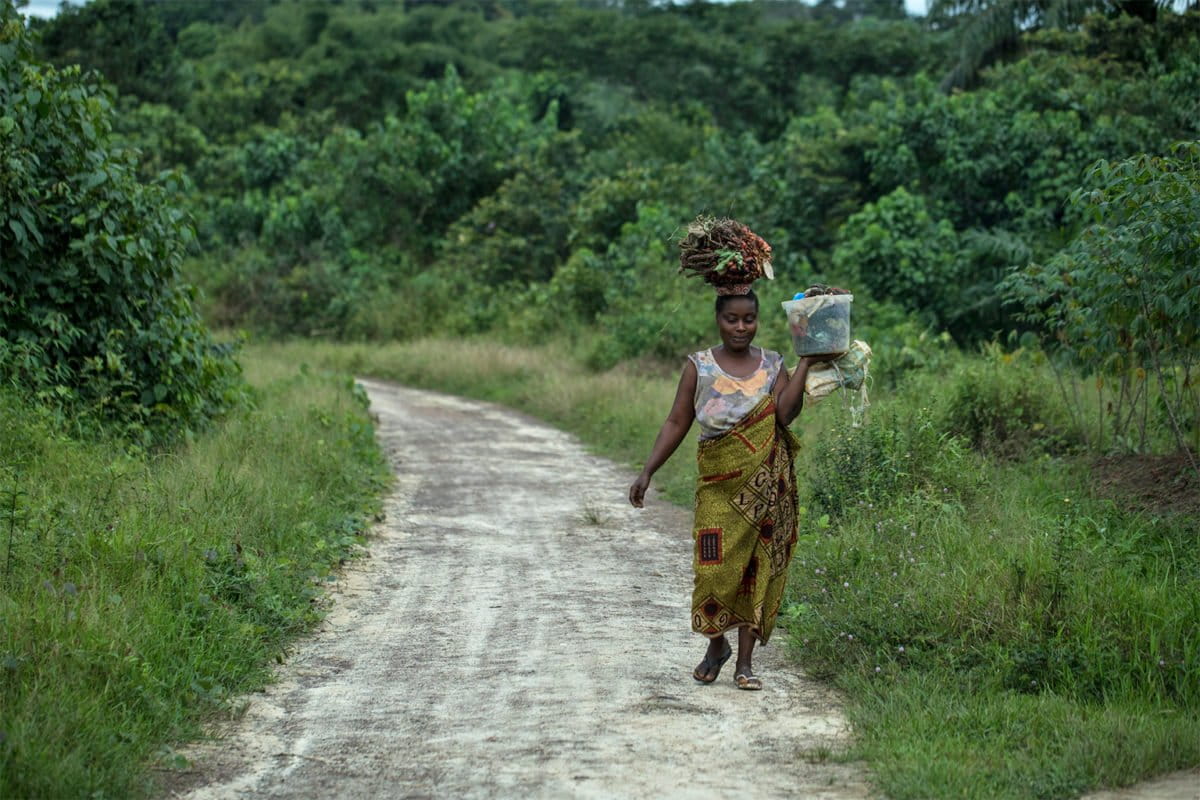 A woman walks through a forest in Liberia. Image by Open Government Partnership via Flickr (CC BY-2.0).
