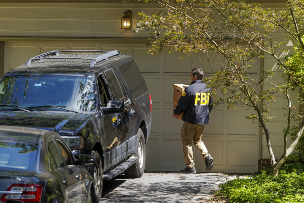 FBI agents leave with boxes from the home of John Bolton, President Trump’s former national security adviser, after serving a warrant in Bethesda, Md., Aug. 22, 2025. The investigation into Bolton began to pick up momentum during the Biden administration, when U.S. intelligence officials collected information that appeared to show that he had mishandled classified information, according to people familiar with the inquiry. (Jason Andrew/The New York Times)