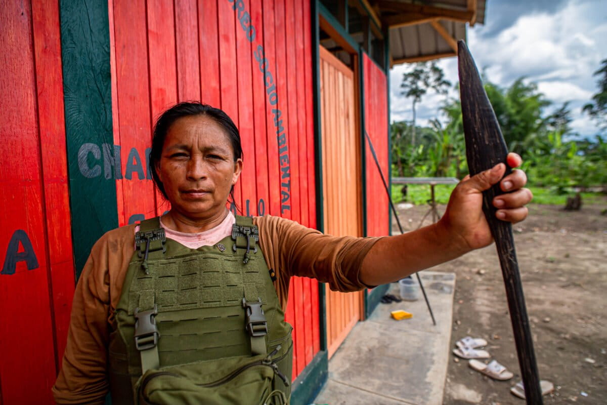 A female member of the Charip territorial monitoring group standing outside a monitoring post holding a traditional spear. Image courtesy of Maria Goretii/Convoca.