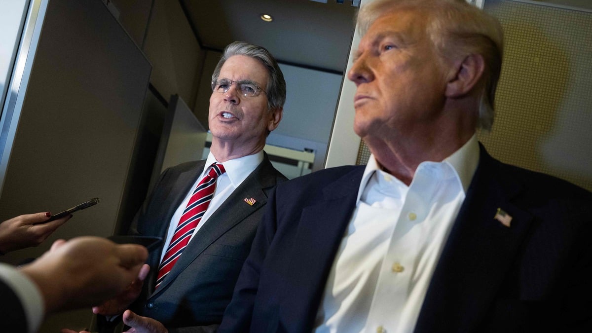 US President Donald Trump looks on as US Treasury Secretary Scott Bessent (left) speaks to the media aboard Air Force One on October 27, 2025