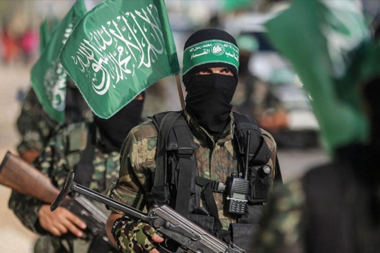 Hamas fighters march during a military display in Gaza, carrying flags and firearms. (AA photo )