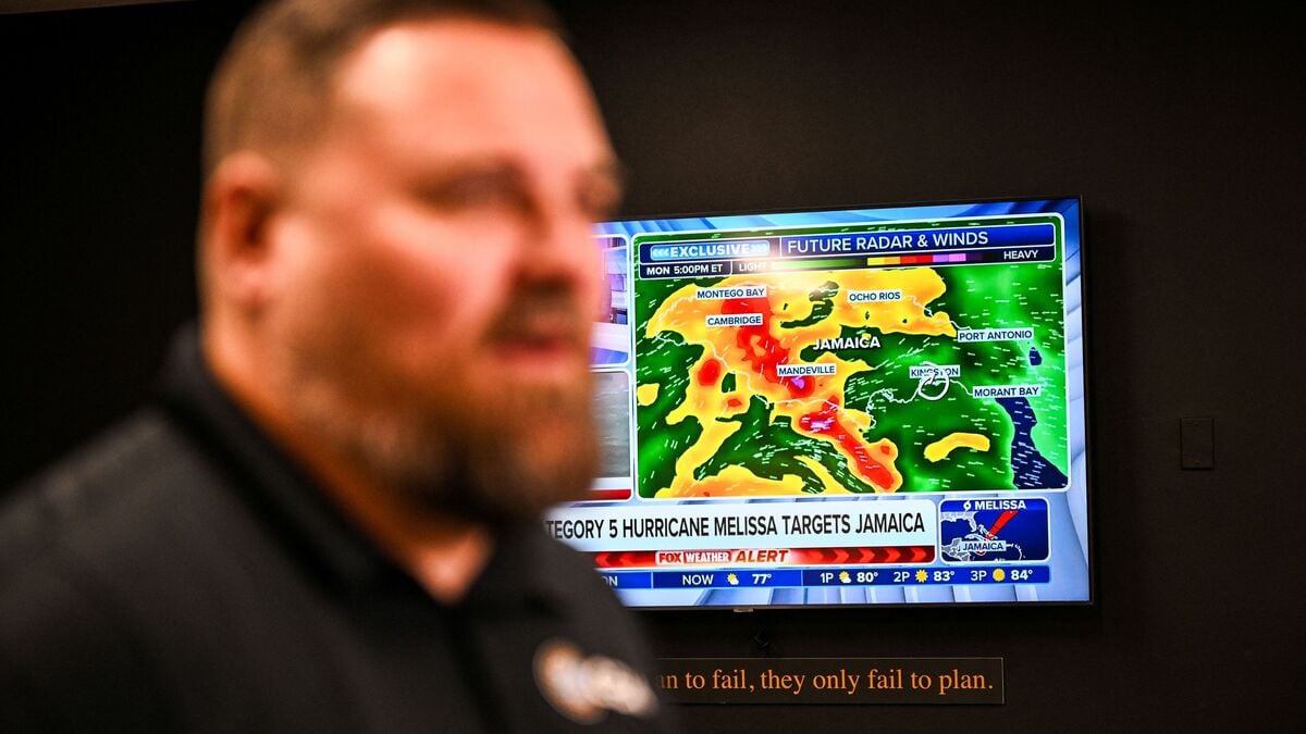 A weather news channel displays Hurricane Melissa updates. Hurricane Melissa threatened Jamaica with potentially deadly rains after rapidly intensifying into a top-level Category 5 storm, as residents scrambled for shelter from what could be the island's most violent weather on record. Melissa has already been blamed for at least four deaths in Haiti and the Dominican Republic, and was set to unleash torrential rains on parts of Jamaica in a direct hit on the Caribbean island. (Photo by CHANDAN KHANNA / AFP)
