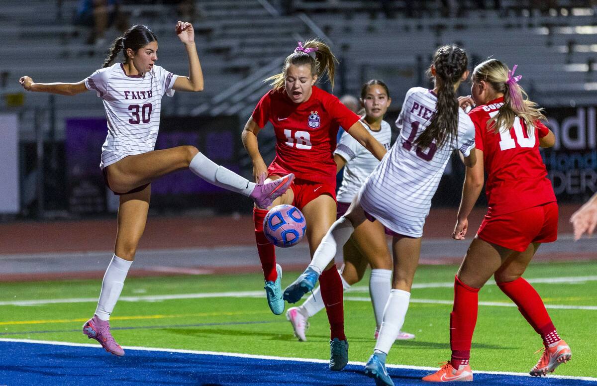 Faith Lutheran's Presley Lujan (30) works to clear the ball past Coronado's Payton Jones (18) a ...
