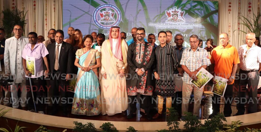 Prime Minister Kamla Persad-Bissessar, fourth from left, and Saudi Arabia Ambassador Abdullah Muhammad, pose for a group picture with Ministers Saddam Hosein, Barry Padarath and recipients at the Caroni lease distribution ceremony at the Diplomatic Centre, St Ann