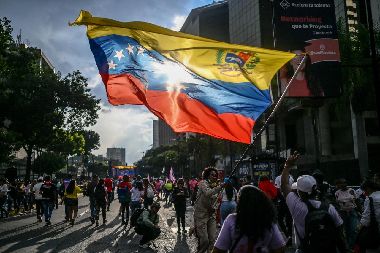 A supporter of Venezuelas President Nicolas Maduro waves a Venezuelan flag during a protest outside the United Nations headquarters in Caracas on October 6, 2025. (AFP Photo)
