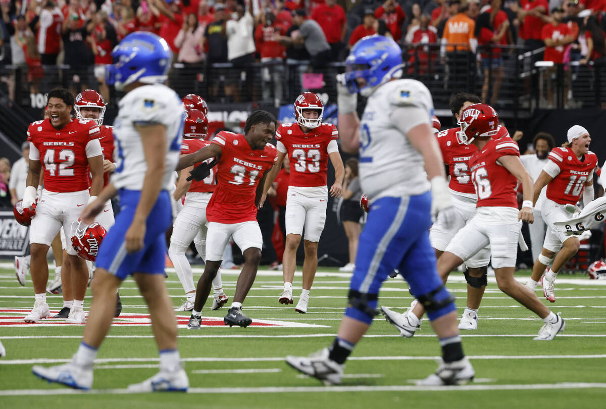 UNLV players celebrate their 51-48 win as Air Force Falcons players walk off the field during t ...