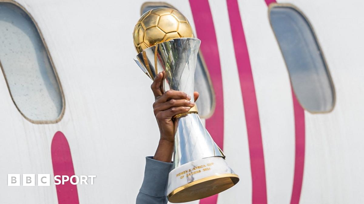 Tabitha Chawinga in all dark blue kit and pink boots is pictured mid-stride running with a football which has a star motif on it during a match between Lyon and Arsenal in the Uefa Women's Champions League. Chawinga has her head up and is looking at an opponent who is seen from behind in red and white kit coming to challenge her