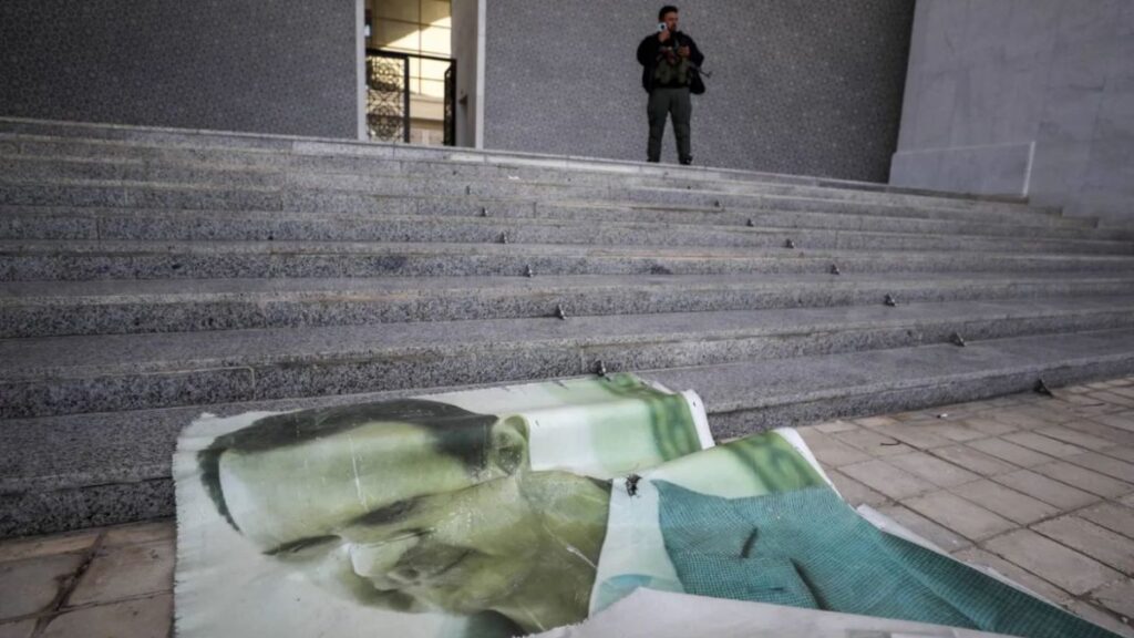A torn portrait of Bashar al-Assad inside the Presidential Palace in Damascus after the fall of his regime and the entry of opposition forces on December 8, 2024 (AP).