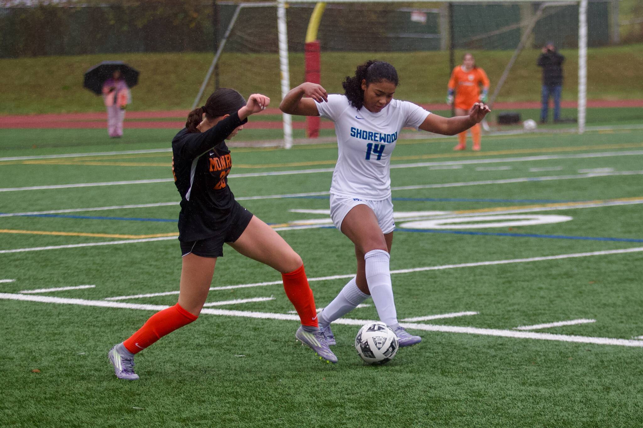 Shorewood senior Jasmyn Jacobs (right) lunges towards a 50/50 ball against Monroe junior Ella Glynn during the Stormrays' 1-1 (4-2 penalty kicks) match against the Bearcats in the District 1 3A quarterfinals at Monroe High School on Nov. 1, 2025. (Joe Pohoryles / The Herald)