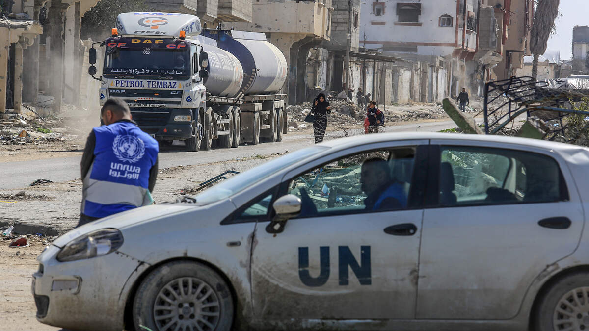 February 17, 2025, Palestinian Territories, Rafah: A UNRWA employee leans against a UN vehicle as trucks carrying humanitarian aid cross the Kerem Shalom border crossing into the Gaza Strip.