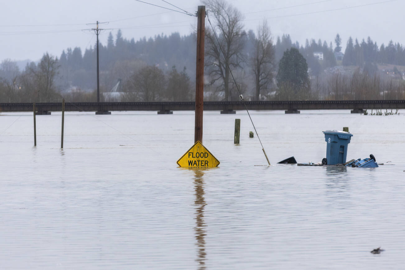 Floodwater from the Snohomish River partially covers a flood water sign along Lincoln Avenue on Thursday, Dec. 11, 2025 in Snohomish, Washington. (Olivia Vanni / The Herald)