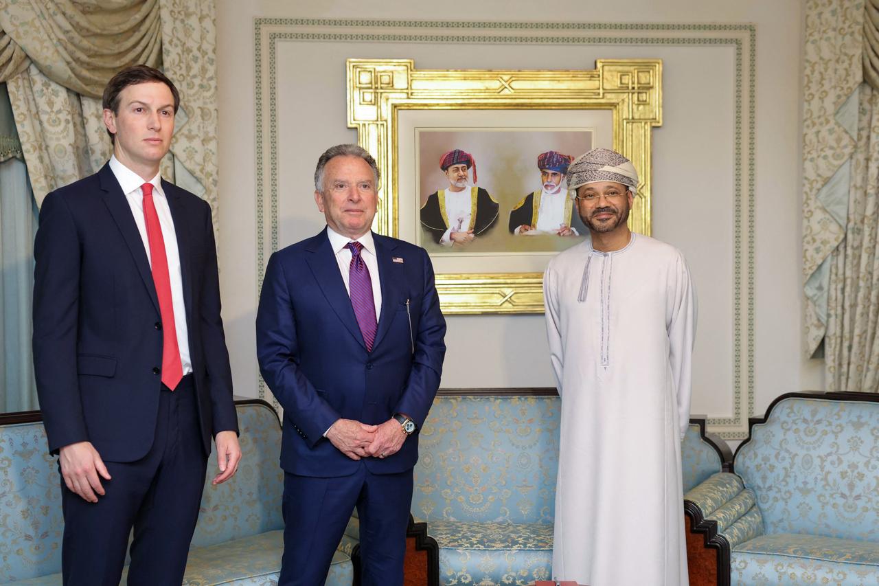 In this handout photo released by the Omani Ministry of Foreign Affairs on February 6, 2026, US special envoy Steve Witkoff (C), Jared Kushner (L) and Oman’s Foreign Minister Badr bin Hamad al-Busaidi pose for a photo during a meeting in Muscat, Oman.