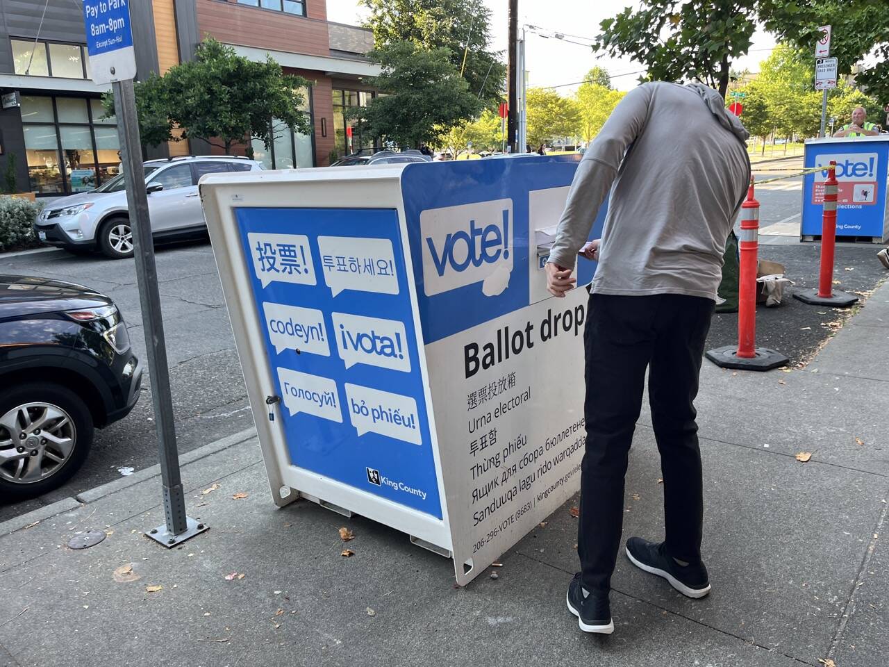 A voter puts a ballot in the drop box at the Ballard branch of the Seattle Public Library in King County in August 2024. This voting location is one of the most popular in the county. (Laurel Demkovich/Washington State Standard)
