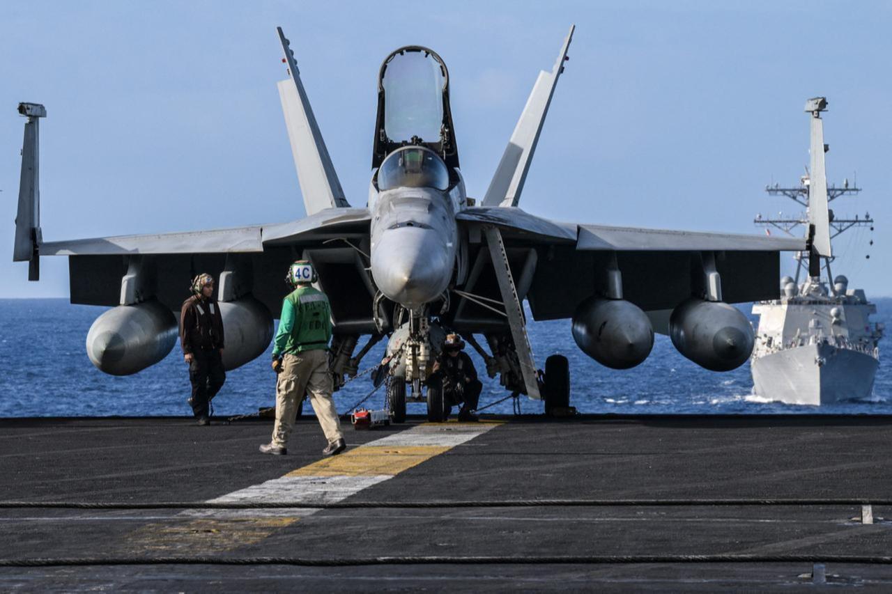 Crew members stand by an F/A-18 on the flight deck of the USS Carl Vinson aircraft carrier on January 31, 2024. (AFP Photo)
