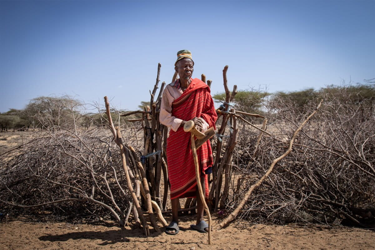 A Turkana elder stands in front of a boma in the settlement of Kapese. Image by Christopher Clark for Mongabay.