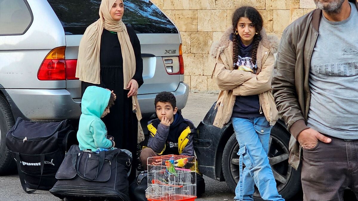 People stand next to their personal belongings as they prepare to flee Beirut's southern suburbs after the latest issued Israeli warning to the residents to evacuate on 5 March