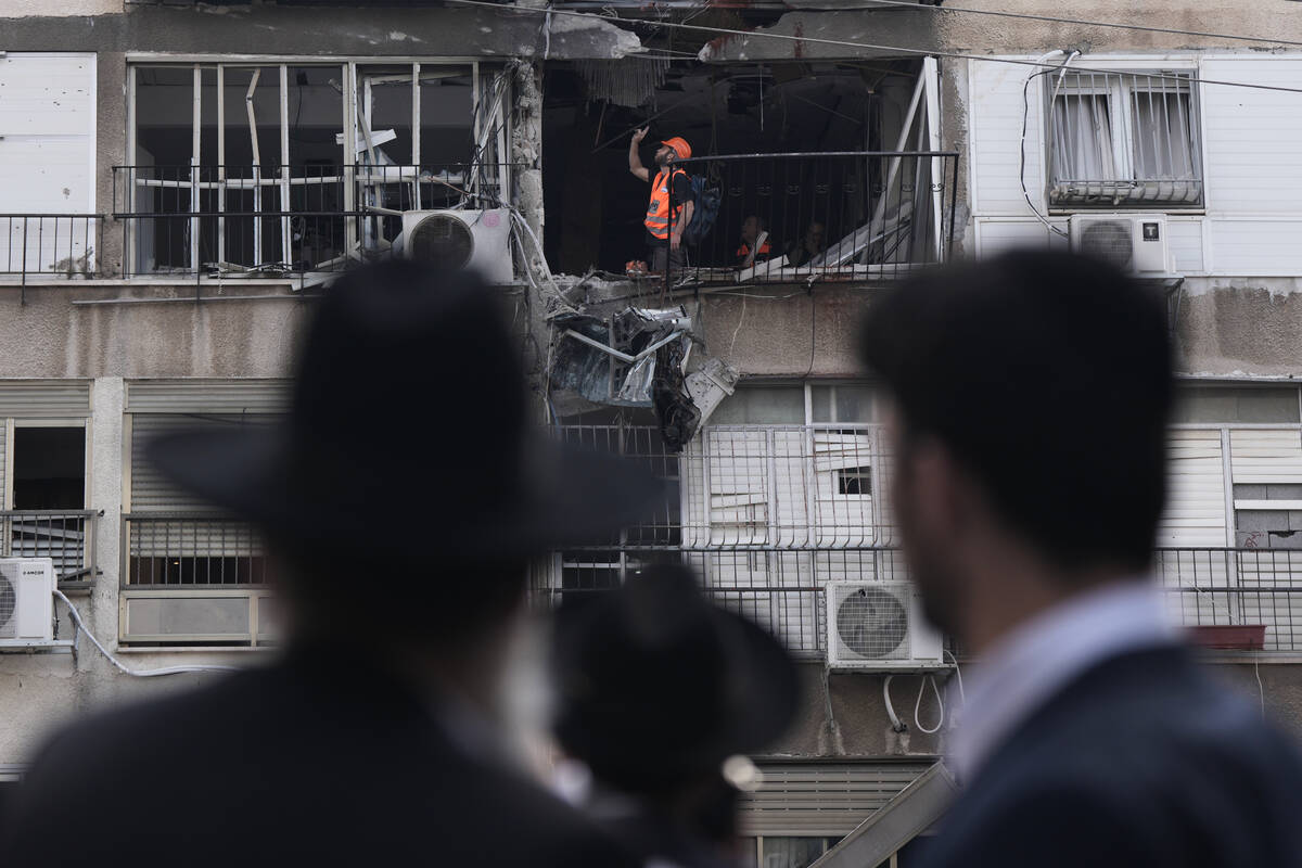 Home Front Command officer works at an apartment damaged after an Iranian strike in Bnei Brak, ...