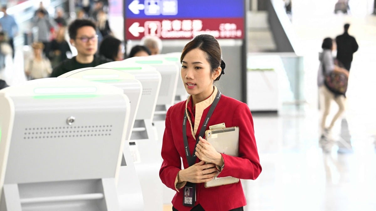 A Cathay Pacific staff member helps a passenger check in at Hong Kong international airport on 11 March 2026