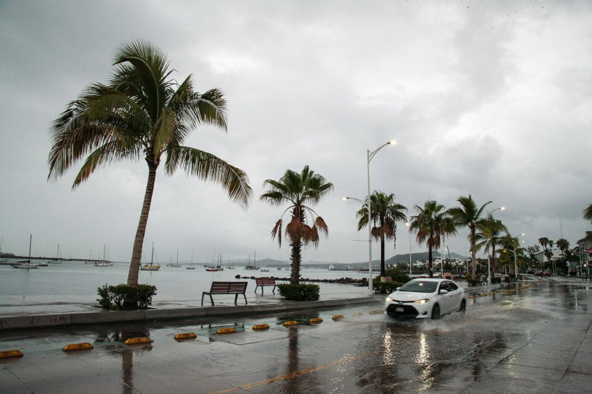A car drives down the flooded ocean-front malecón of La Paz in 2022 after Hurricane Kay