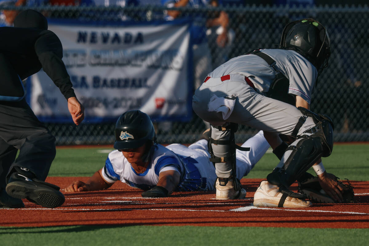 Basic’s Dillon Lee (8) slides safely into home plate during the baseball game on Friday, ...