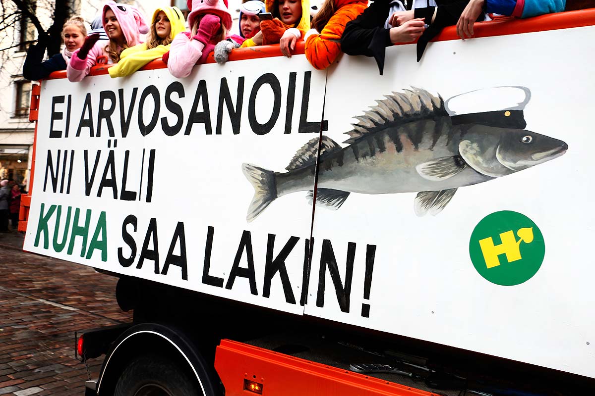 A group of upper secondary school seniors smiling and celebrating together outdoors before their matriculation exams in a photograph by Tony Öhberg for Finland Today.