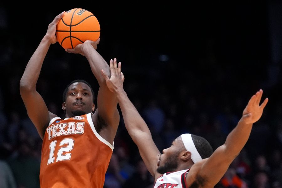Texas guard Tramon Mark (12), left, scores a go-ahead basket with 1 second remaining during the second half in a First Four college basketball game in the NCAA Tournament against North Carolina State, Tuesday, March 17, 2026, in Dayton, Ohio. (AP Photo/Kareem Elgazzar)