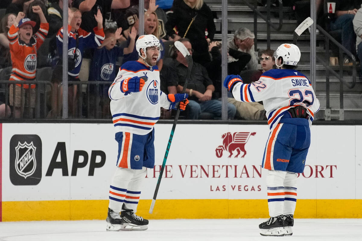 Edmonton Oilers defenseman Evan Bouchard, left, celebrates after scoring against the Vegas Gold ...