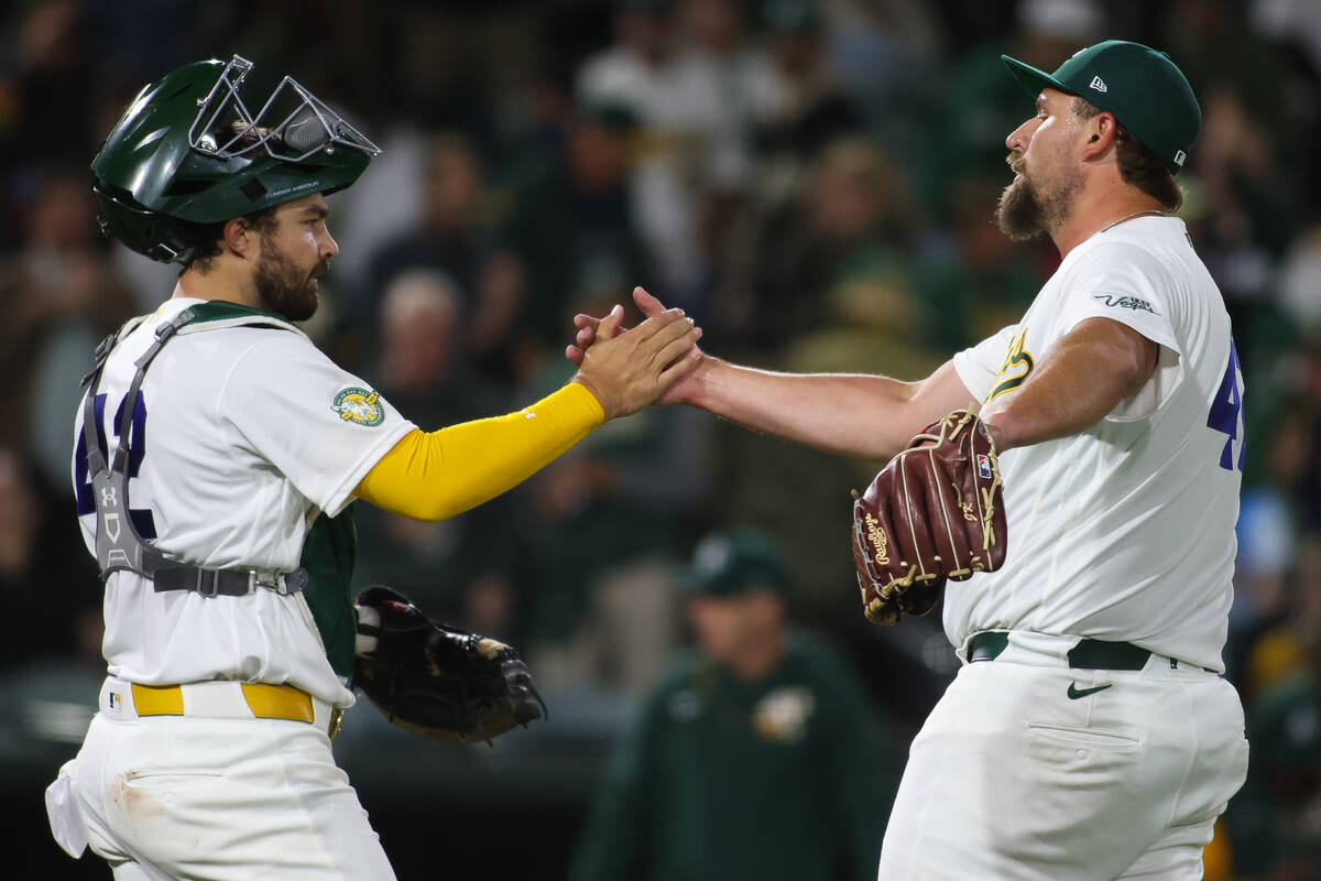 Athletics pitcher Joel Kuhnel, right, shakes hands with Shea Langeliers after the Athletics vic ...