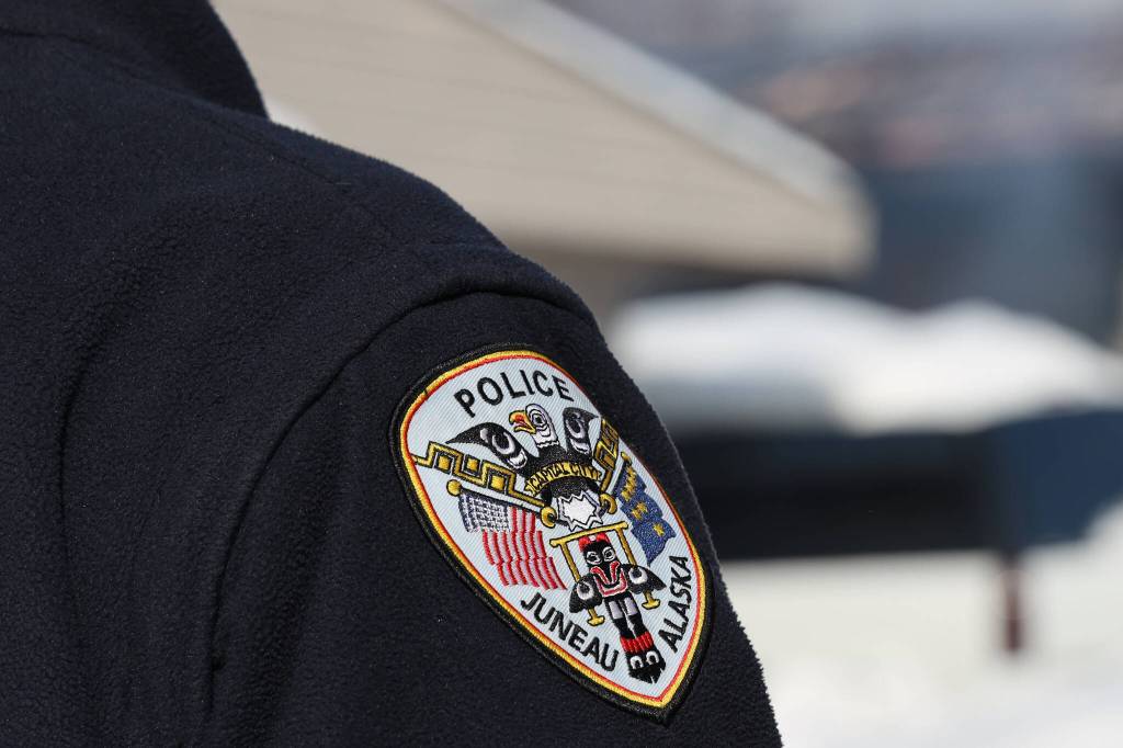 A Juneau police officer stands on duty in early March. (Clarise Larson/Juneau Empire File)