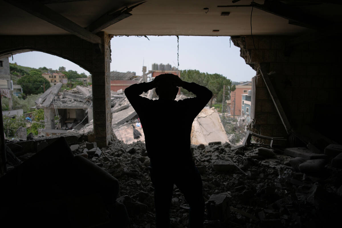 Assem Abdallah reacts as he enters his friend apartment destroyed in a Israeli airstrike in Kfa ...