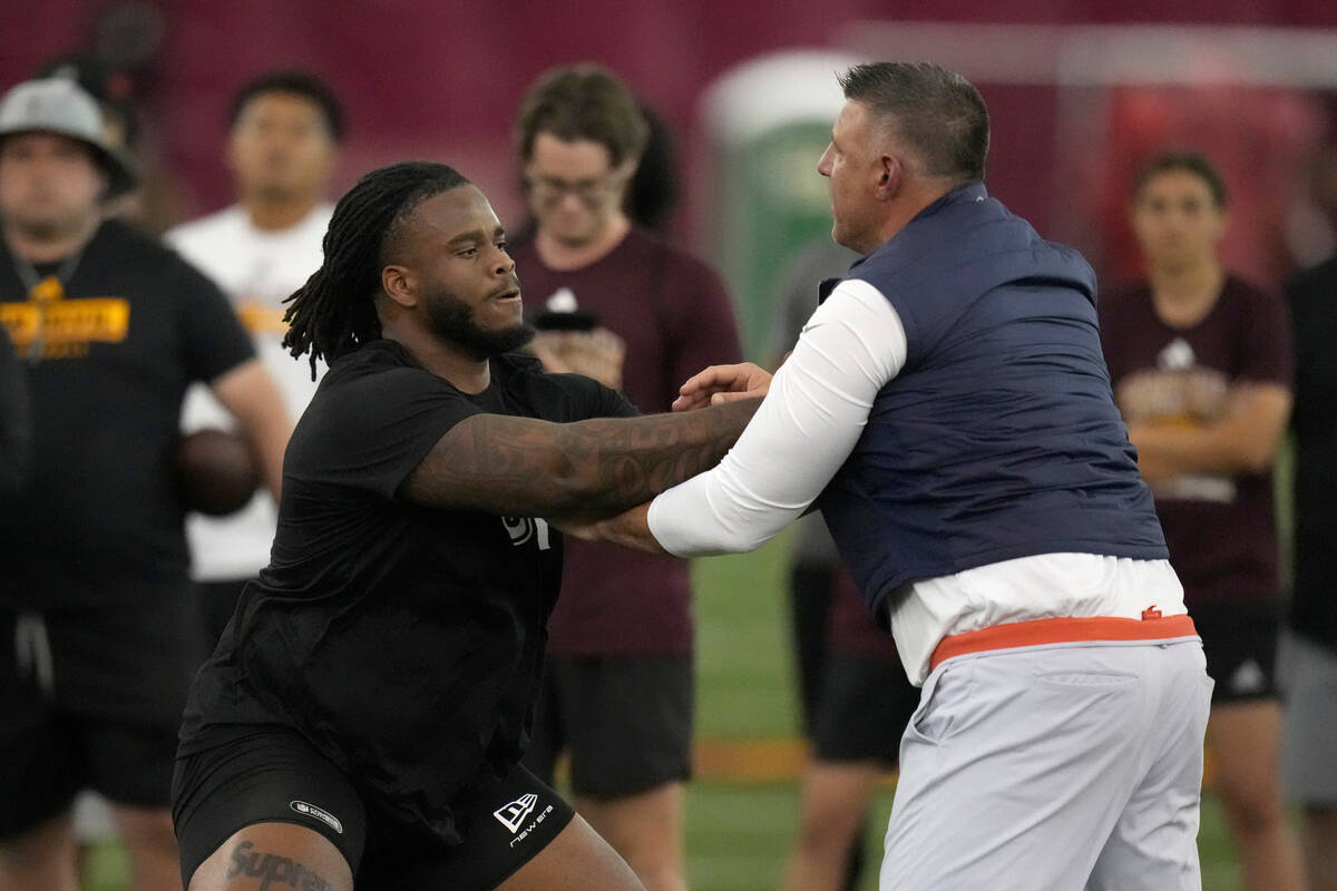 Arizona State offensive lineman Max Iheanachor, left, works with New England Patriots head coac ...