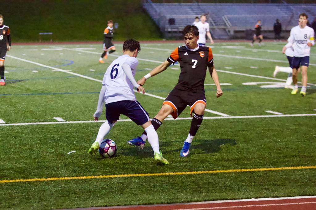 Monroe senior Tony Granados (right) tries to take the ball from Everett sophomore Parker Smith during the Bearcats 2-0 win against the Seagulls at Monroe High School on April 14, 2026. (Joe Pohoryles / The Herald)