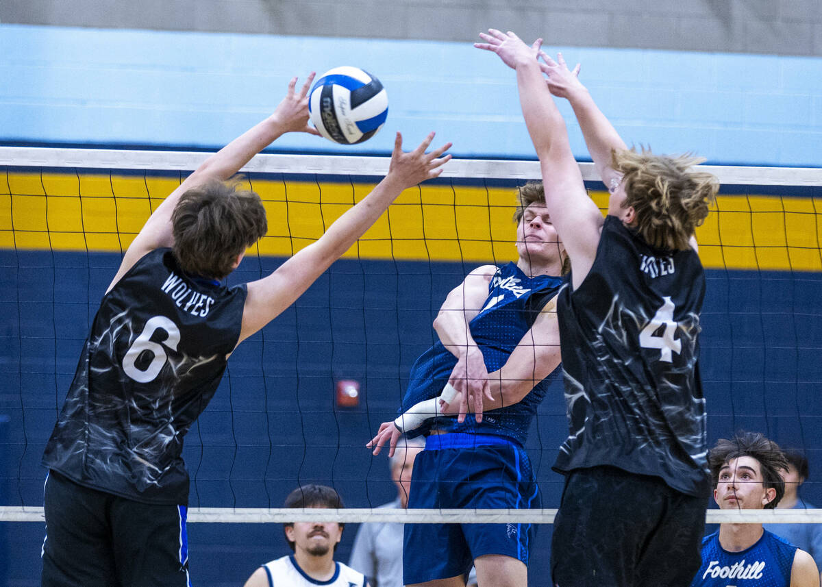 Foothill's Cooper Stearman (10) spikes the ball past Basic's Paxton Hughes (6) and Re ...