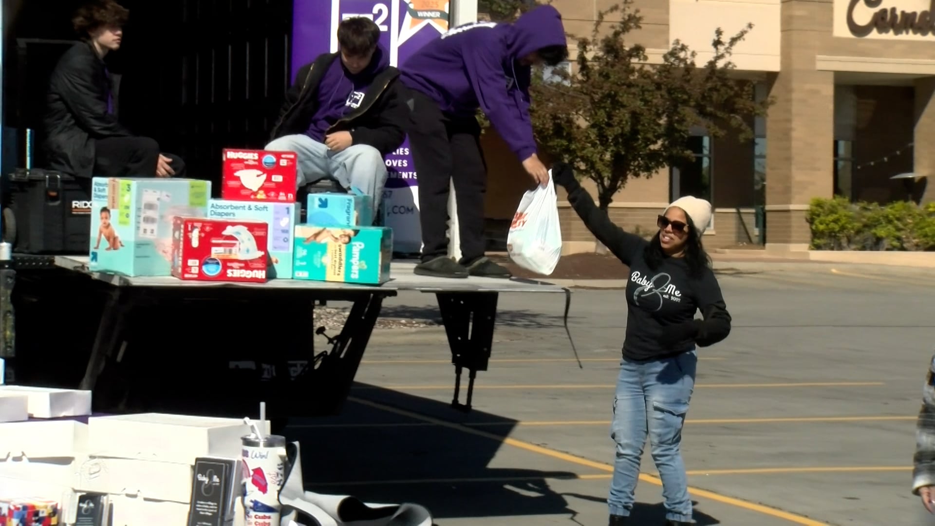 Three Lincoln women work together to stuff a truckload full of items for moms in need