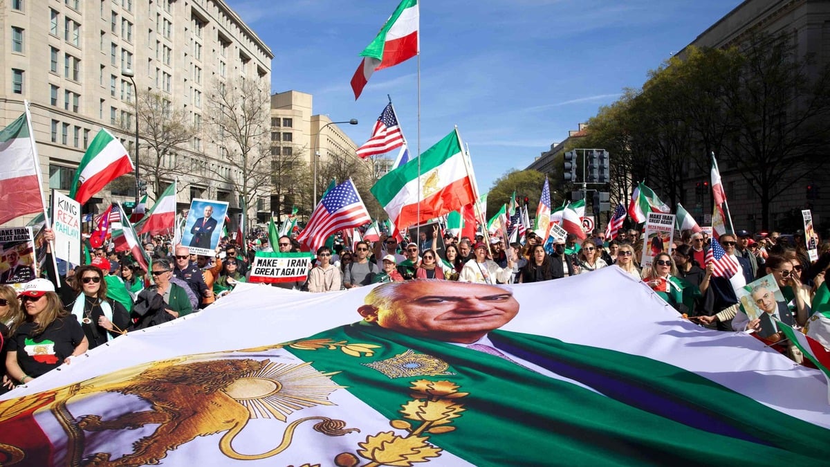Demonstrators wave Iranian pre-1979 Islamic Revolution and US flags and hold a large banner with an image of Reza Pahlavi, son of the last shah of Iran, as they march toward the White House during a rally in support of Iranians' fight for freedom, in Washington, DC, on March 29, 2026. The event, organized by DCProtests4Iran, brought together members of the Iranian diaspora from the Washington, DC metropolitan area and surrounding states. (Photo by Amid FARAHI / AFP)
