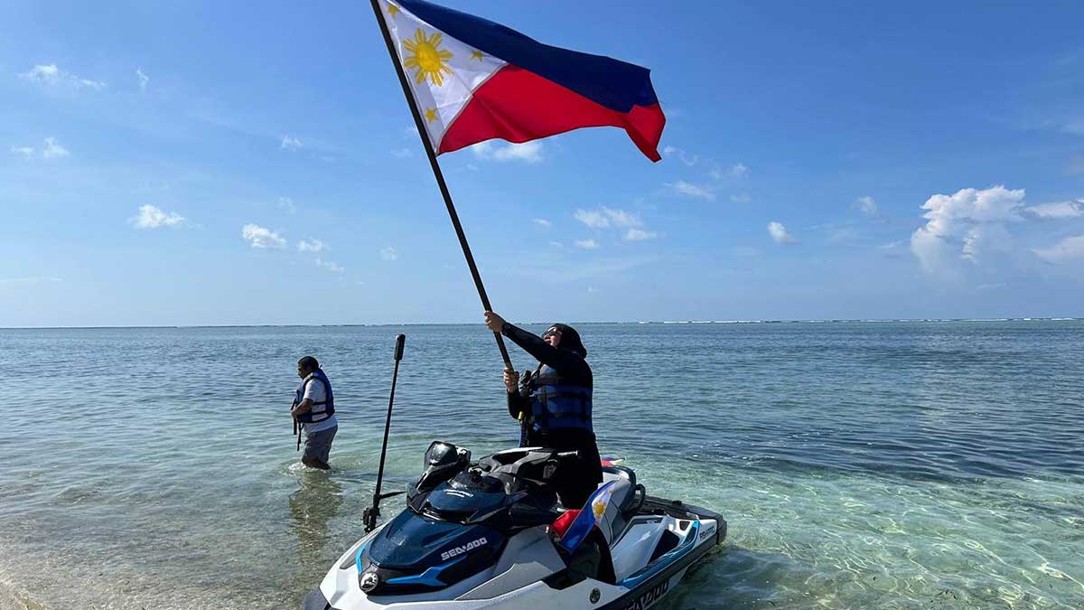 NO JOKE Akbayan Rep. Dadah Kiram Ismula arrives by jet ski at Pag-asa Cay 2 (Sandy Cay) on Sunday and raises high the Philippine flag. This was the Atin Ito activist coalition&rsquo;s fourth mission to the West Philippine Sea, challenging China&rsquo;s trespassing into Philippine waters. &mdash;ATIN ITO COALITION