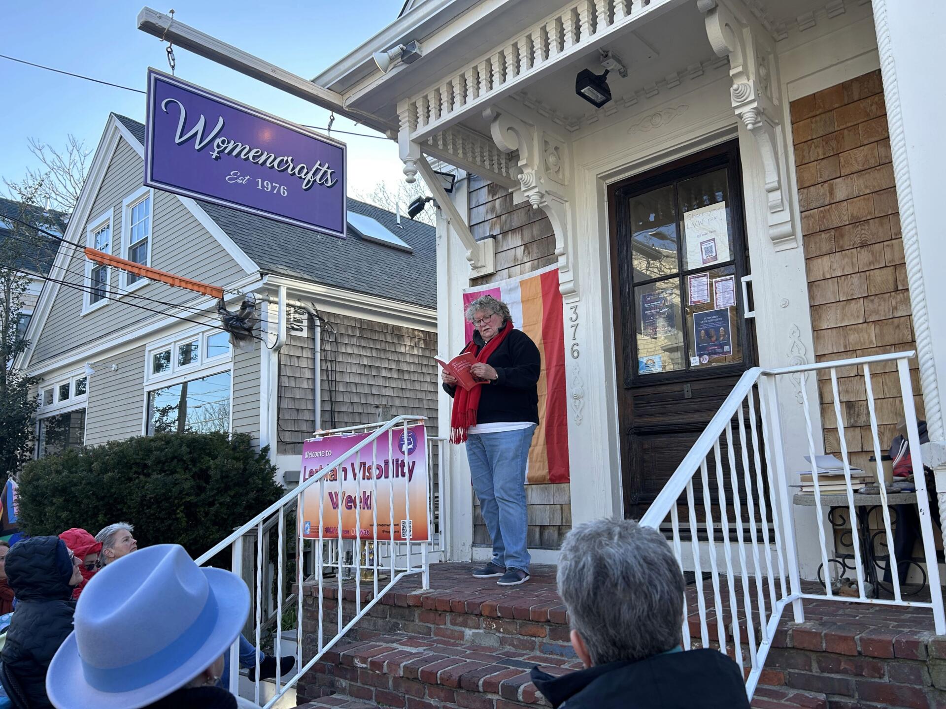 Singer and artist Suede performing a reading on the stoop of Womencrafts in Provincetown. (Amanda Beland/WBUR)