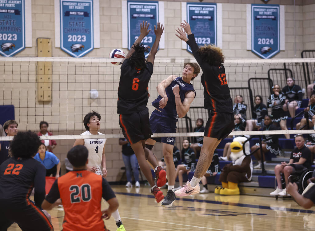 Mojave's Matthew Banks (6) and Kaleb Law (12) block an attack from Sky Pointe's Brad ...