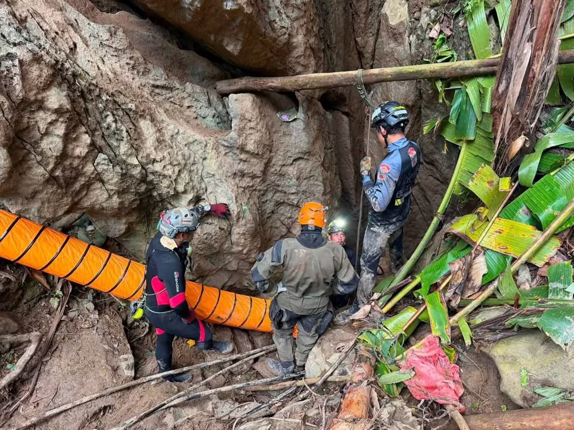 Rescuers evacuate the first of five villagers found trapped in a cave in Laos; Two still missing