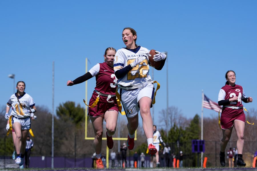 FILE - An Augustana University player, front, runs from a Concordia University, St. Paul player during a women's college flag football game, April 7, 2025, in St. Paul. Minn. (AP Photo/Abbie Parr, File)