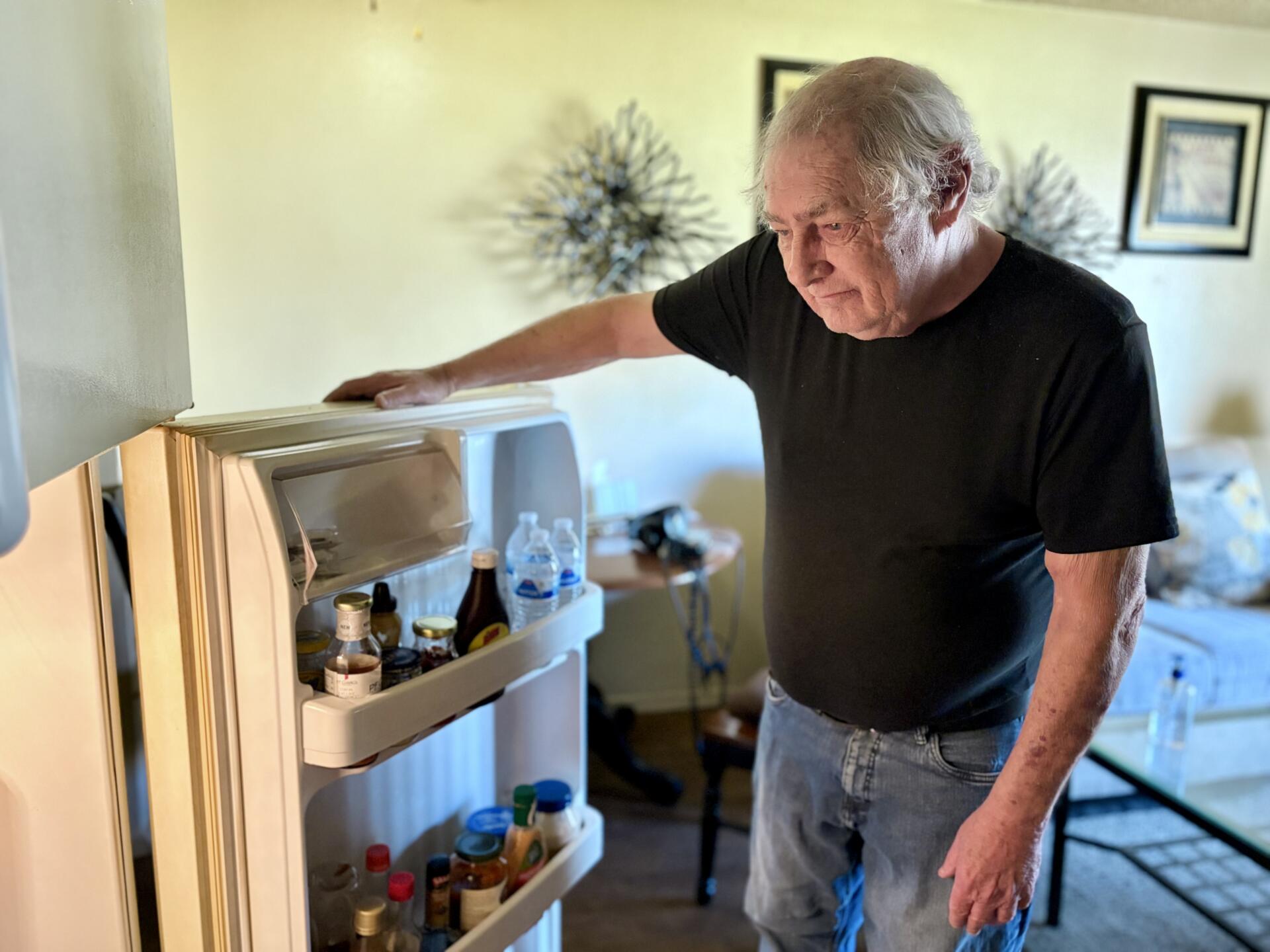 69-year-old Lee Rosen looks into his refrigerator. (Peter O'Dowd/Here & Now)