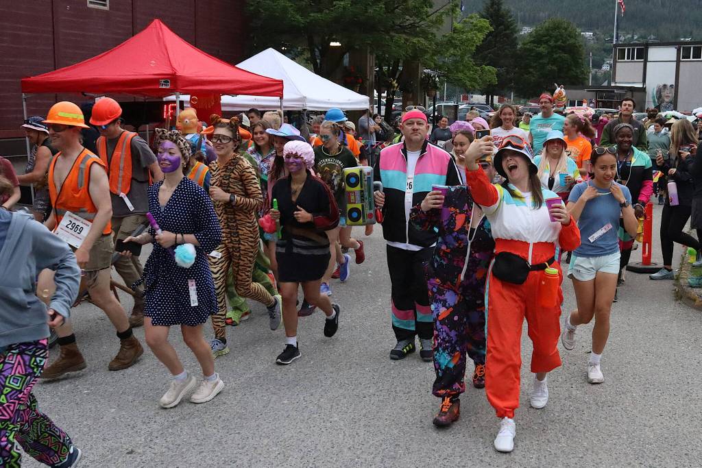 Runners, many dressed in unconventional attire, take off from the starting line outside Centennial Hall during the 2024 Only Fools Run At Night. (Mark Sabbatini / Juneau Empire file photo)