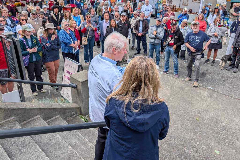 Former U.S. Rep. Brian Baird, left, speaks to a crowd next to Natasha Ryan, spokesperson for the city of Edmonds, during a launch for Edmonds Serves on Saturday, June 6, 2026, in Edmonds, Washington. Edmonds is officially the nation’s first “Community of Service” under an initiative led by Baird. (Michael Henneke / The Herald)