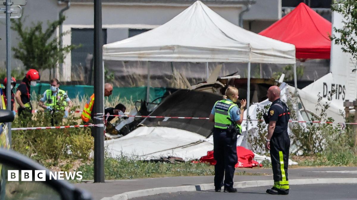 Emergency service workers speak to each other as the attend a light aircraft crash site