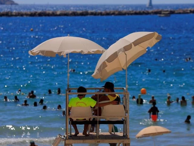 lifeguards watch beachgoers as they bathe at the beach of catalans on a sunny and warm summer day in marseille as an early summer heatwave hits france july 1 2025 reuters manon cruz