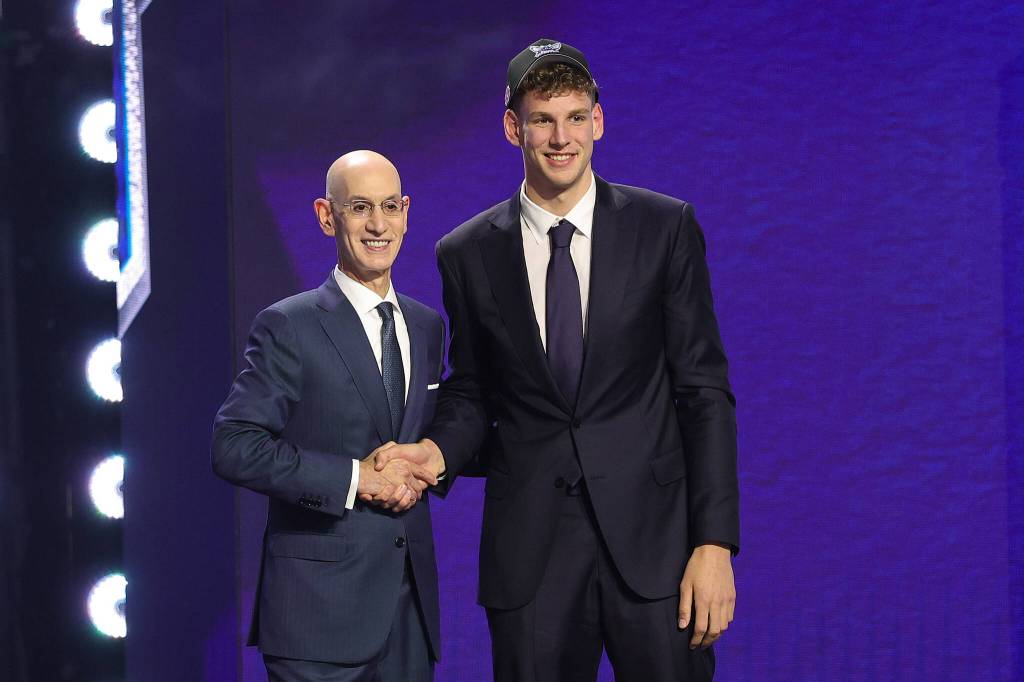 NBA commissioner Adam Silver, left, shakes hands with former Washington Huskies star Hannes Steinbach after he is drafted 14th overall by the Charlotte Hornets during the first round of the NBA Draft at Barclays Center on Tuesday, June 23, 2026, in New York. (Arturo Holmes / Getty Images / Tribune News Services)